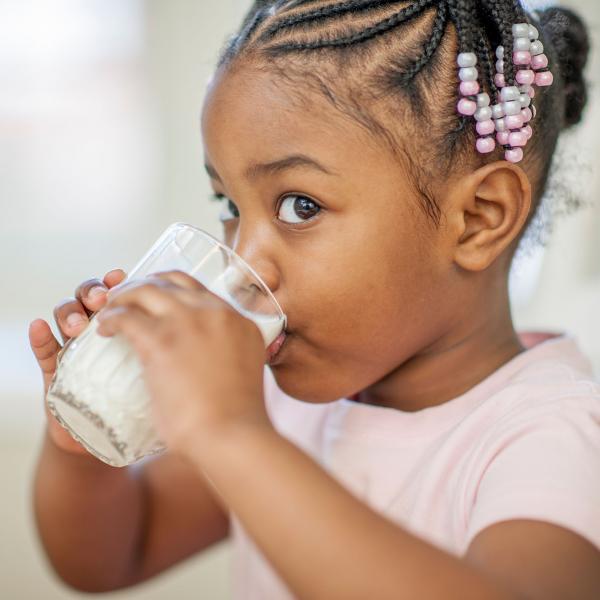 Young child drinking a cold glass of milk