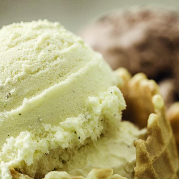 Close up of three scoops of ice-cream. Vanilla, chocolate and mint are featured.